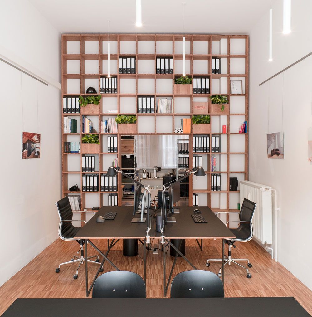 Ein Raum mit einem Tisch und Stühlen mit Ordnern in den Regalen