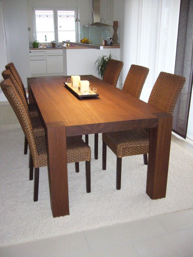 Ein Esstisch mit Korbstühlen und einem Tablett mit Kerzen darauf