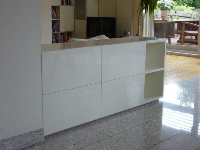 Ein weißer Schrank in einem Wohnzimmer mit einem Fernseher darauf