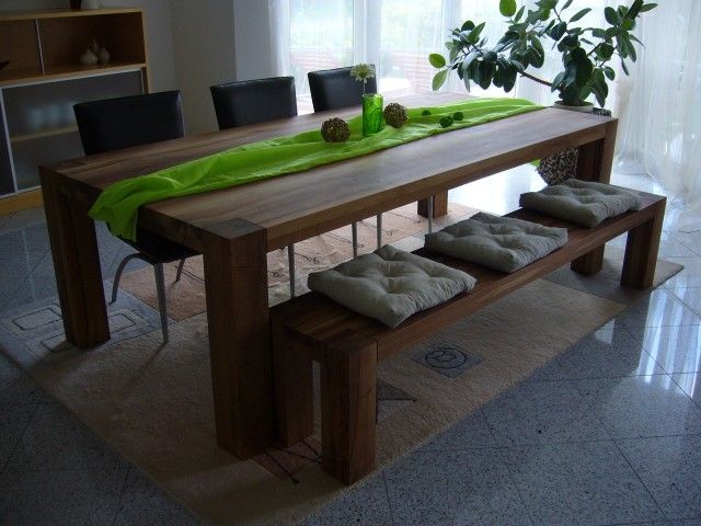 Ein Esstisch mit grünem Tischläufer und einer Bank