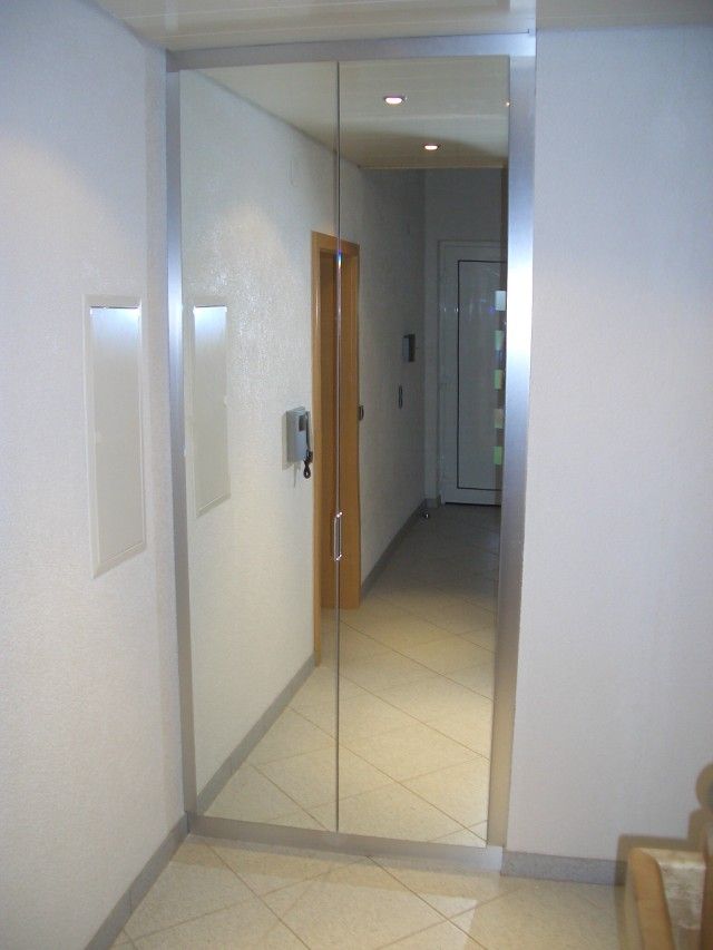 Ein Flur mit einem großen Spiegel an der Wand