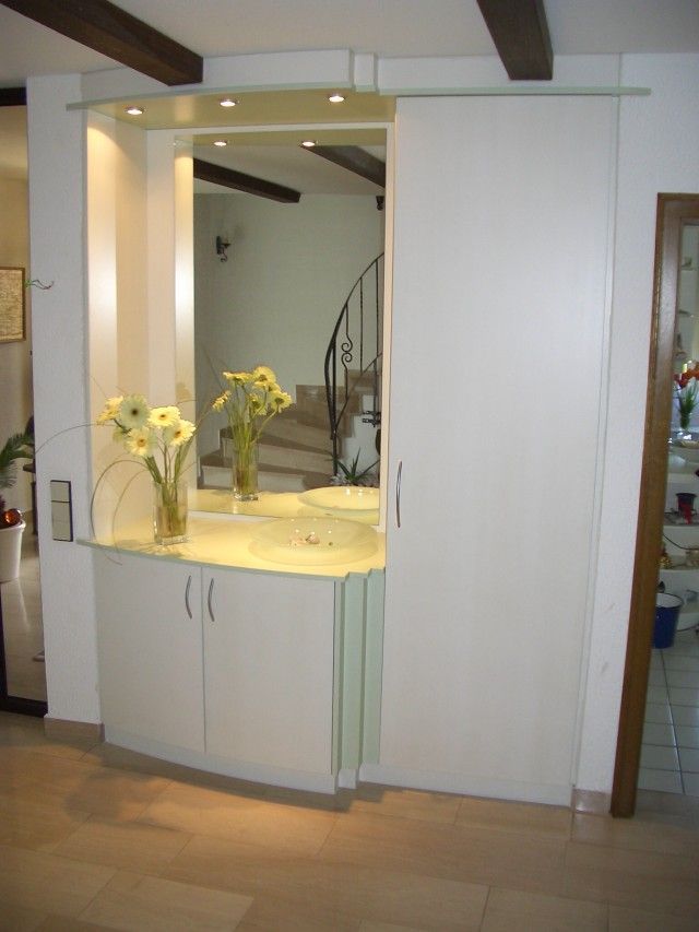 Ein weißer Schrank mit einer Vase mit Blumen darauf