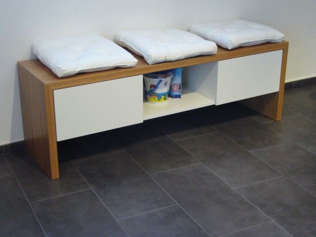 Eine Holzbank mit drei weißen Kissen darauf