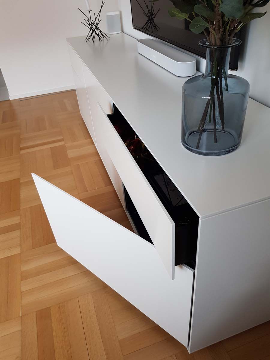 Eine Vase mit Blumen steht auf einem weißen Entertainment-Center