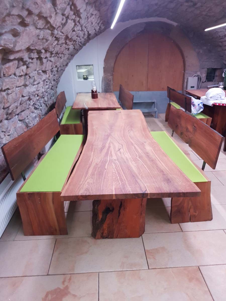 Ein Holztisch mit grünen Kissen steht in einem Raum