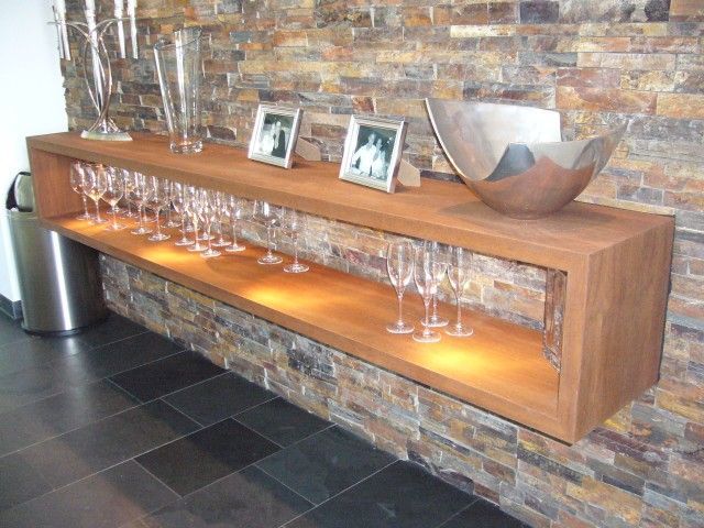 Ein Holzregal mit Weingläsern und Bildern darauf