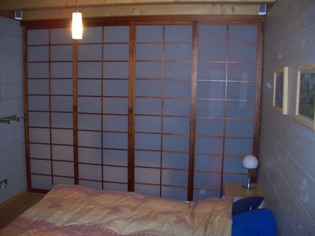 Ein Schlafzimmer mit einem Bett und einer Glasschiebetür