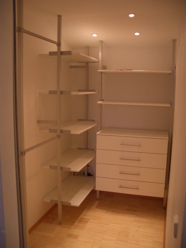 Ein begehbarer Kleiderschrank mit Regalen und einer Kommode