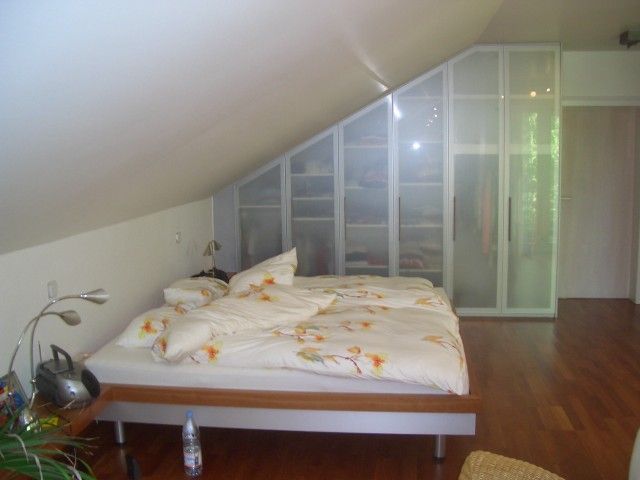 Ein Schlafzimmer mit Dachschräge und Bett
