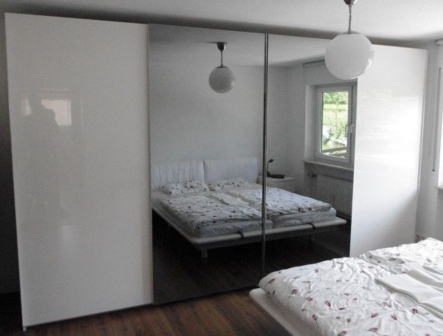 Ein Schlafzimmer mit zwei Betten und einem großen Spiegelschrank