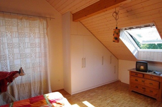 Ein Schlafzimmer mit Dachschräge und Fenster