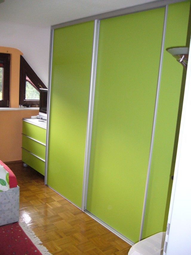 Ein Schlafzimmer mit grünen Schiebetüren und einem Bett