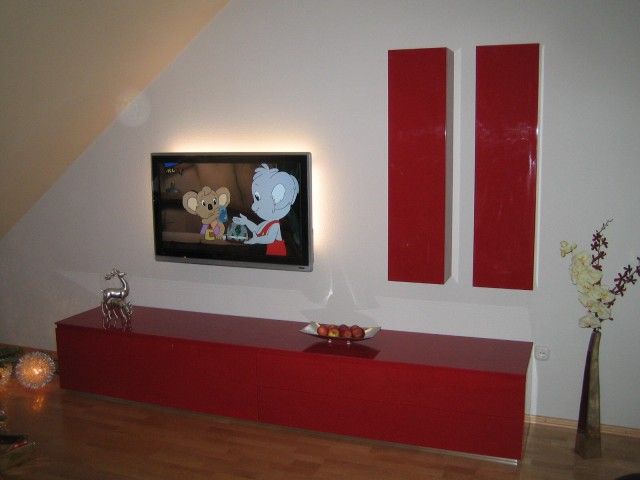 Ein Wohnzimmer mit einem Flachbildfernseher an der Wand