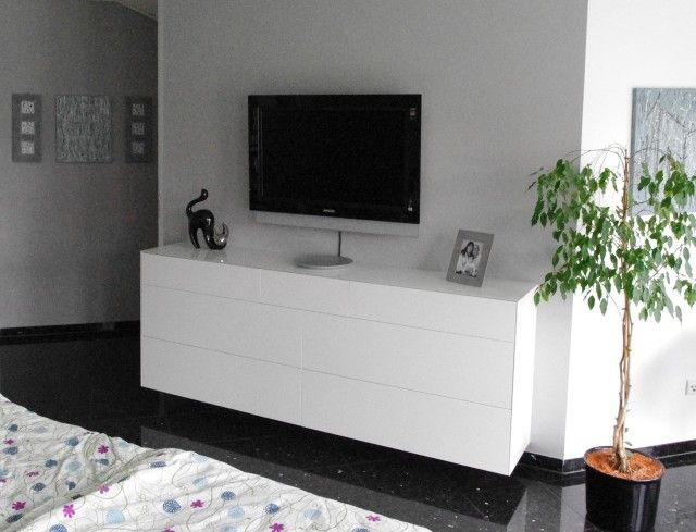 Ein Schlafzimmer mit einer Pflanze und einem Flachbildfernseher