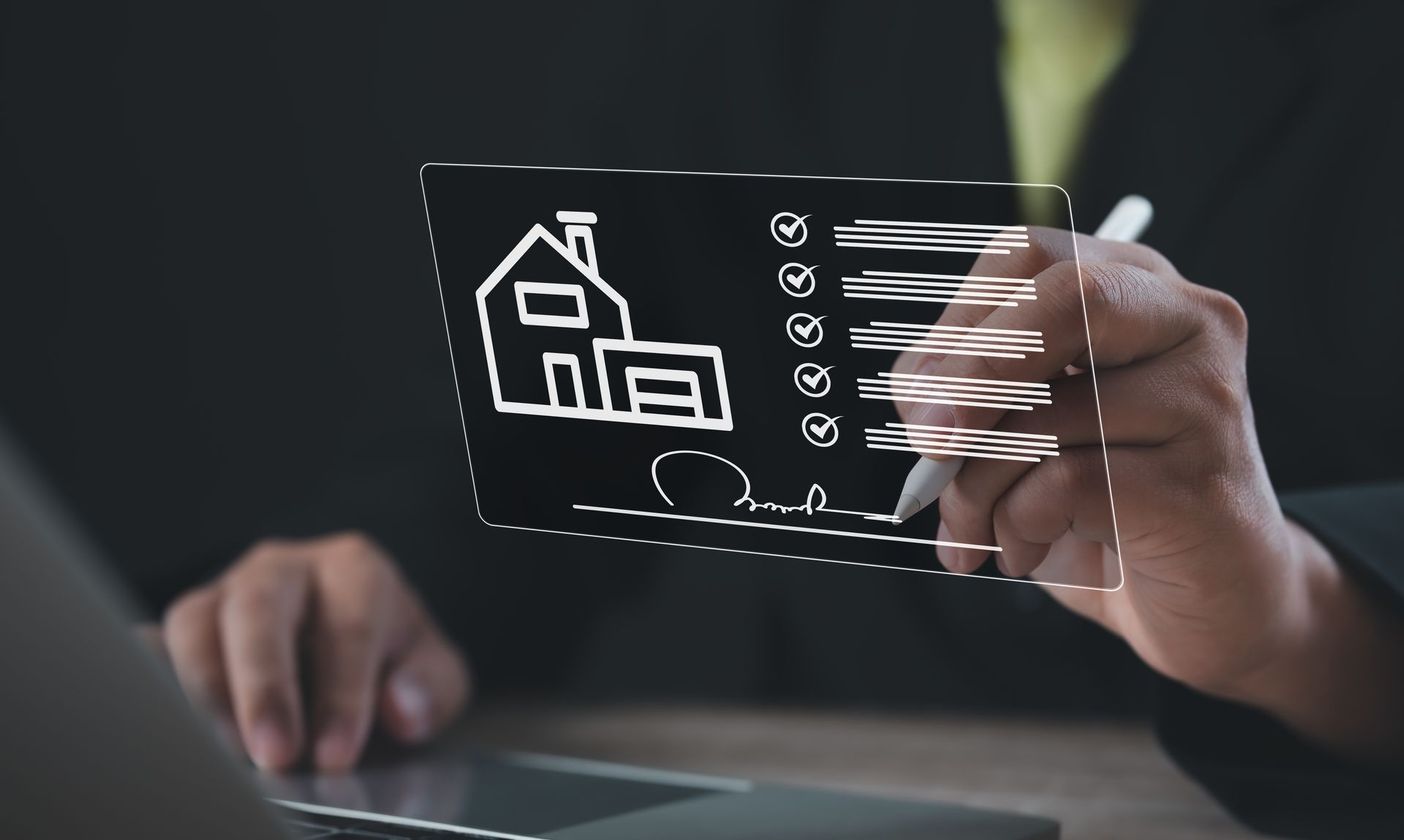 Personne devant un ordinateur et visuel numérique d'une maison et d'une liste de vérification