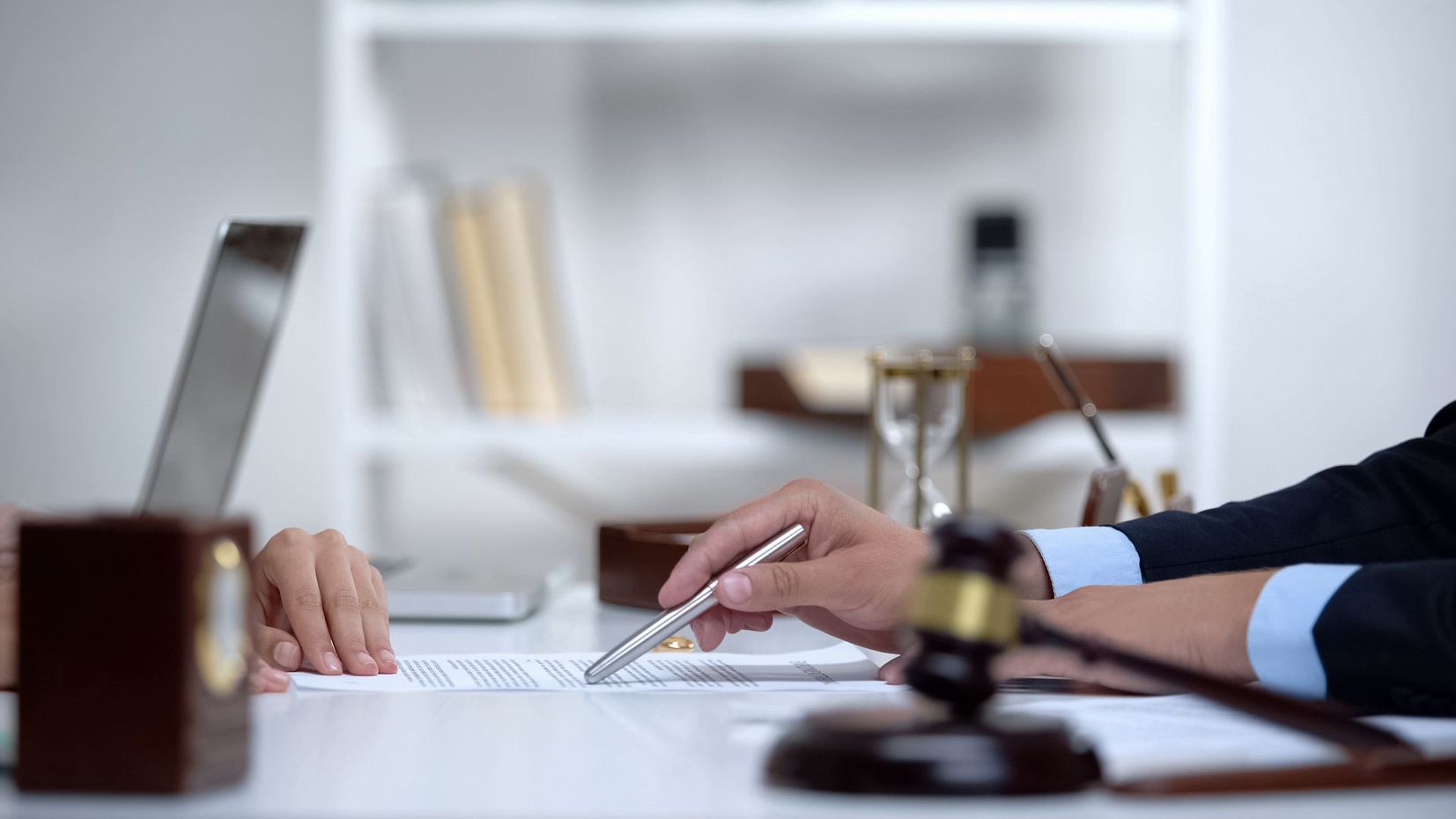 Deux personnes autour du bureau d'un notaire, marteau posé sur la table
