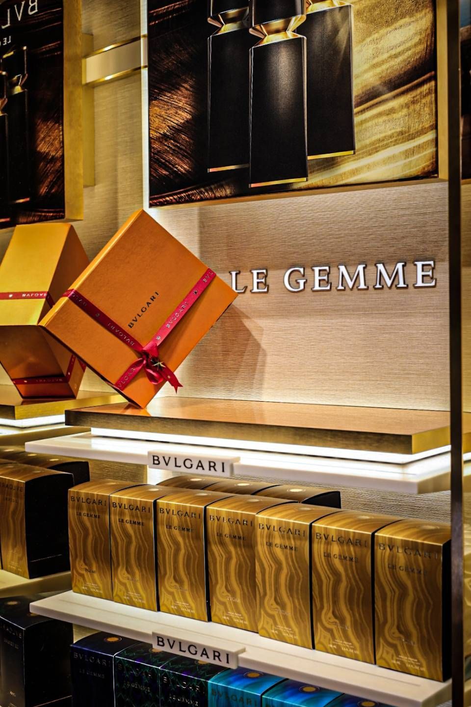 Eine Frau fotografiert Make-up-Produkte auf einem weissen Tisch in einem hellen Raum.