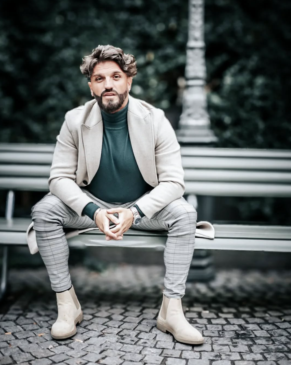 Parfümflakons ausgestellt. Einer ist bonbonförmig mit rosa Akzenten, der andere beige. Gelbes Regal, goldener Hintergrund.