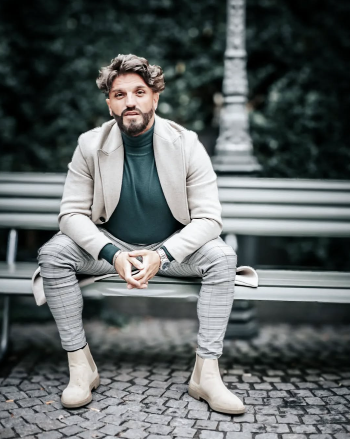 Parfümflakons ausgestellt. Einer ist bonbonförmig mit rosa Akzenten, der andere beige. Gelbes Regal, goldener Hintergrund.