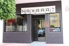 Fachada de tienda con un letrero negro que dice "NAKARA" sobre la entrada y las ventanas.