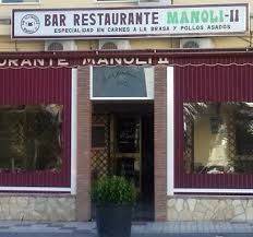Fachada de restaurante con toldos color burdeos y letrero que dice “Bar Restaurante Manoli-II”.