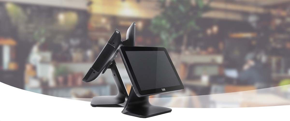 Terminal de punto de venta con pantalla táctil y lector de tarjetas integrado sobre un mostrador, con fondo de tienda borroso.
