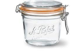 Un bocal de conservation Le Parfait en verre transparent, avec une fermeture à anse métallique et un joint en caoutchouc orange, centré sur un fond blanc.