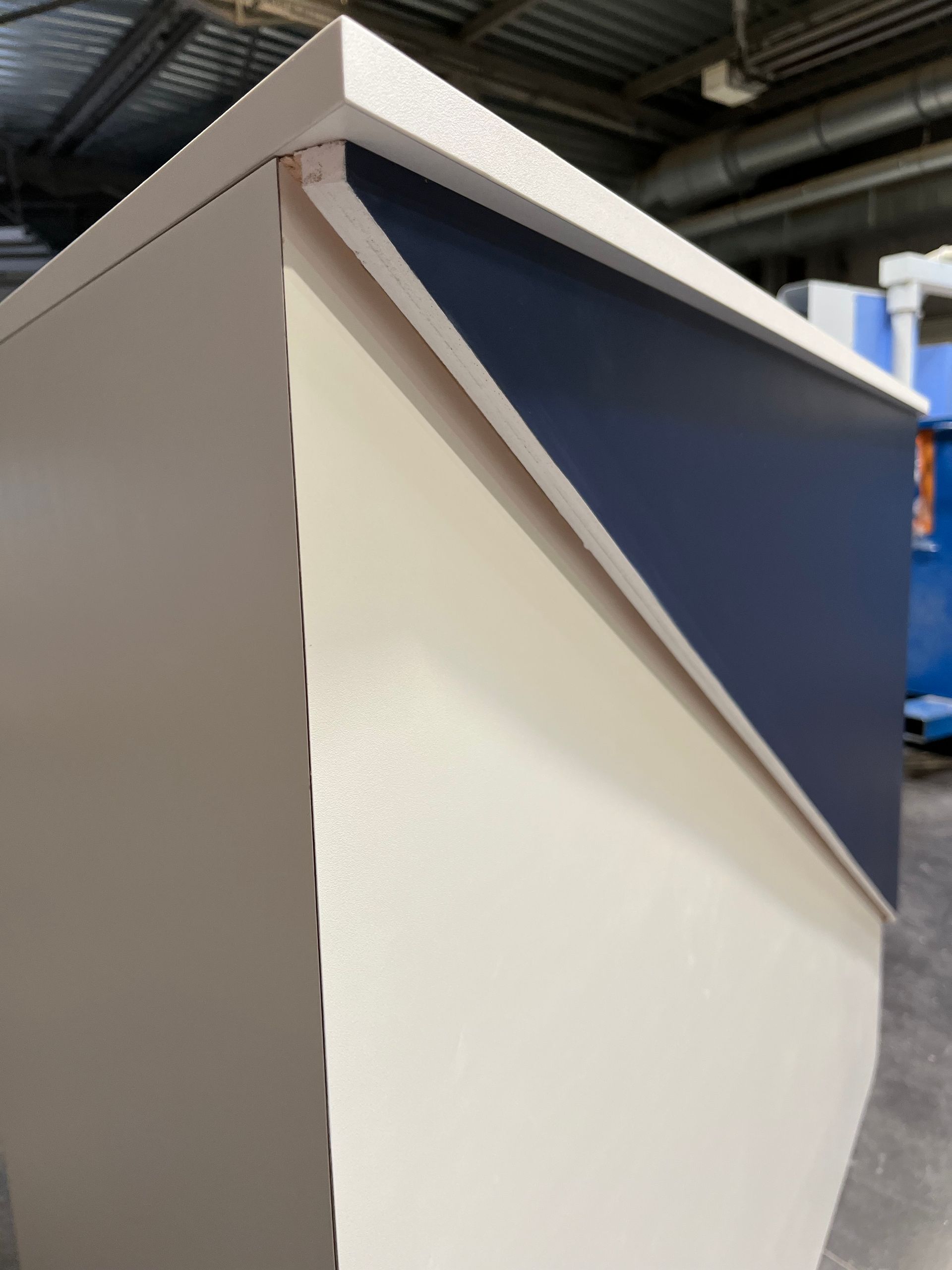 Détails angulaires de meubles blancs et bleu marine dans un atelier.