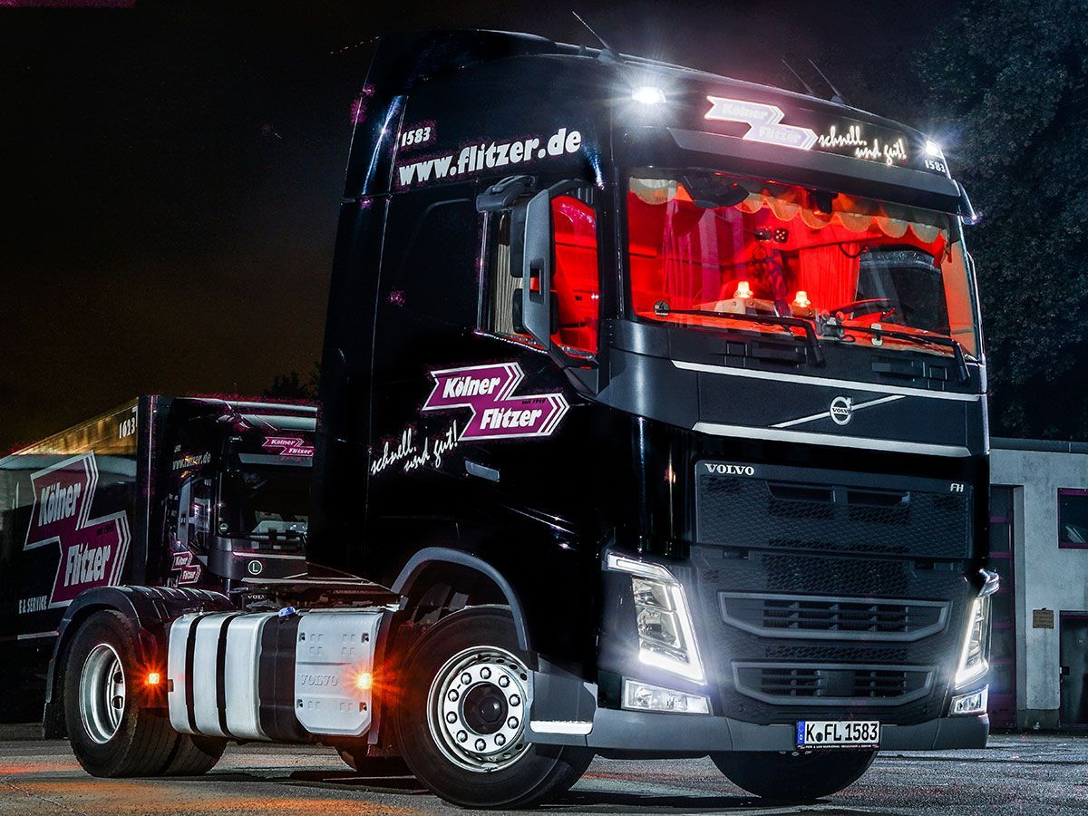 Ein Sattelschlepper von Volvo steht nachts auf einem Parkplatz.
