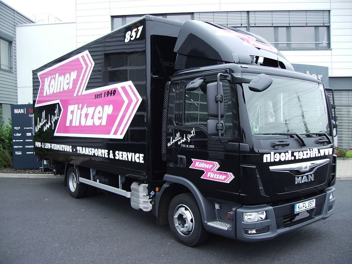 Ein Mann-LKW steht vor einem Gebäude