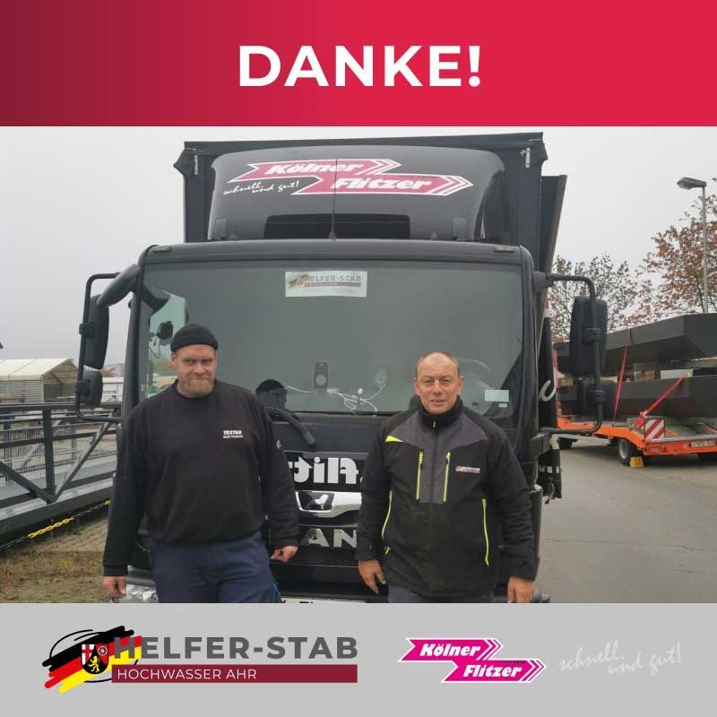 Zwei Männer stehen vor einem LKW mit der Aufschrift „Danke“