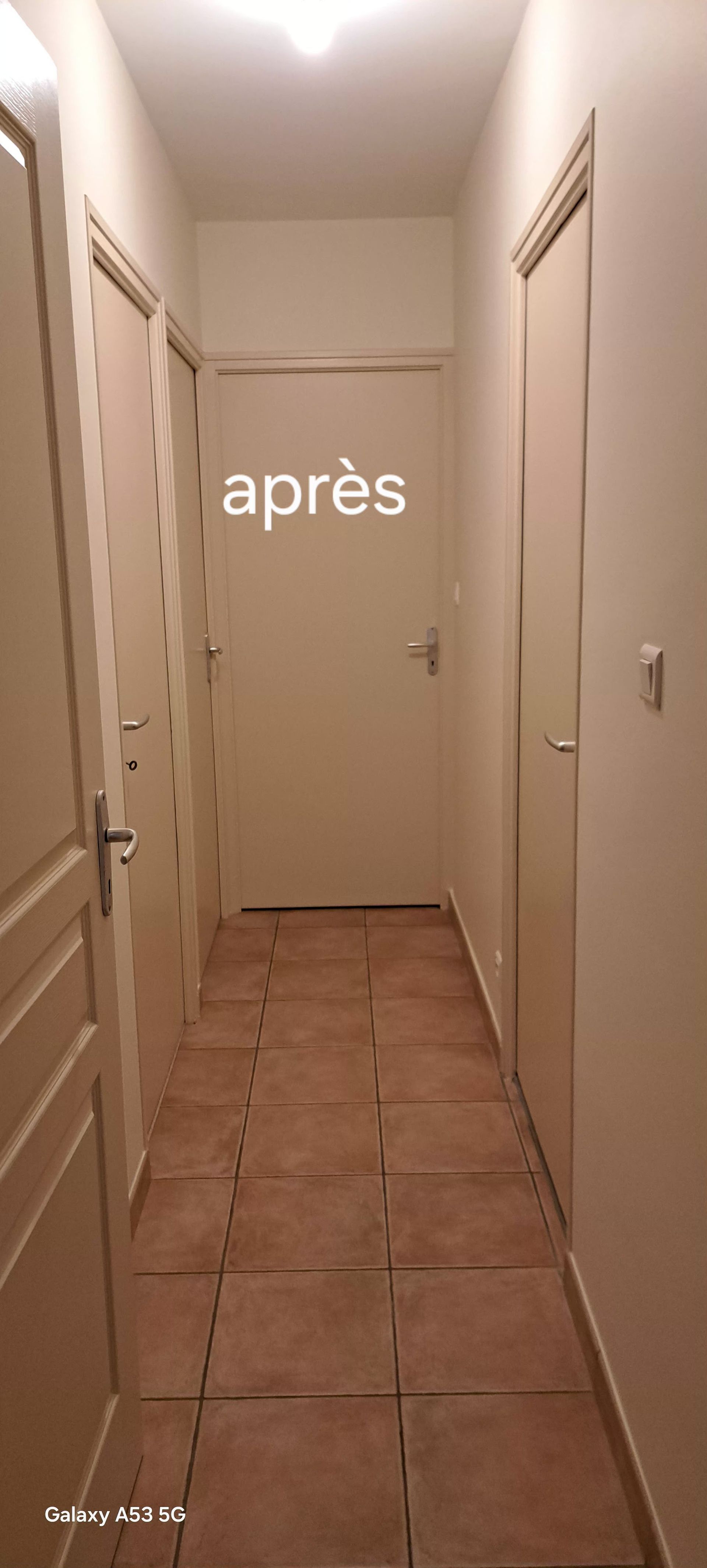 Un couloir avec un sol carrelé clair