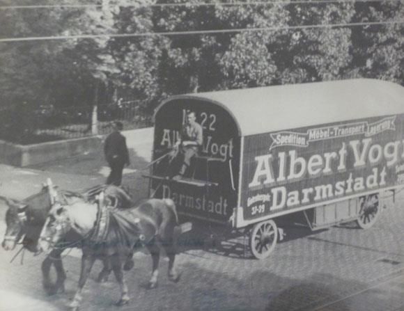 Ein Schwarzweißfoto von zwei Pferden, die einen Wagen von Albert Vogt ziehen