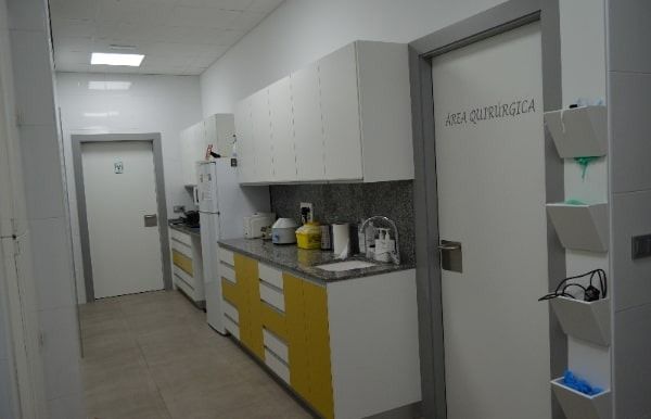 Un largo pasillo con armarios amarillos y armarios blancos en un hospital.