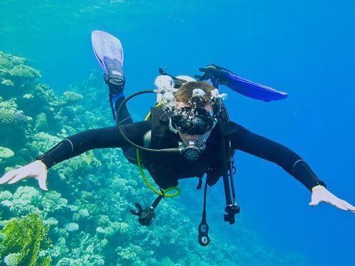 Un buceador está nadando en el océano cerca de un arrecife de coral.