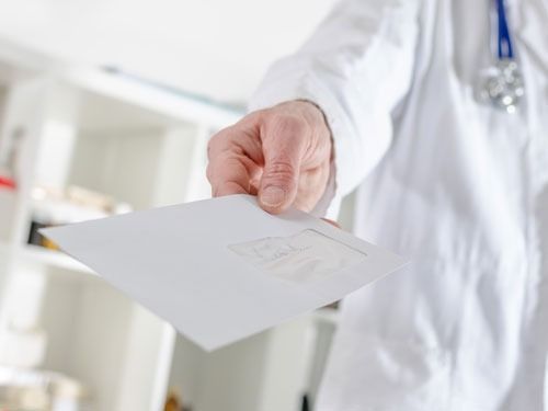 Un médico sostiene un trozo de papel en su mano.