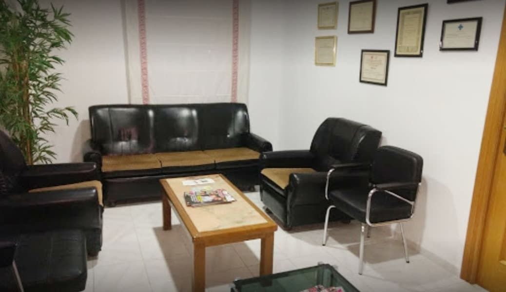 Una sala de estar con un sofá, sillas y una mesa de café.