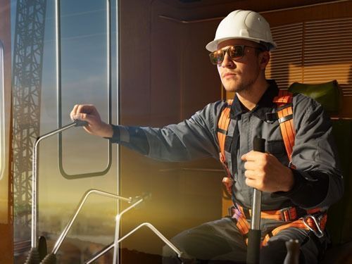 Un hombre que lleva casco y gafas de sol está sentado en una silla.