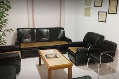 Una sala de estar con un sofá, sillas y una mesa de café.