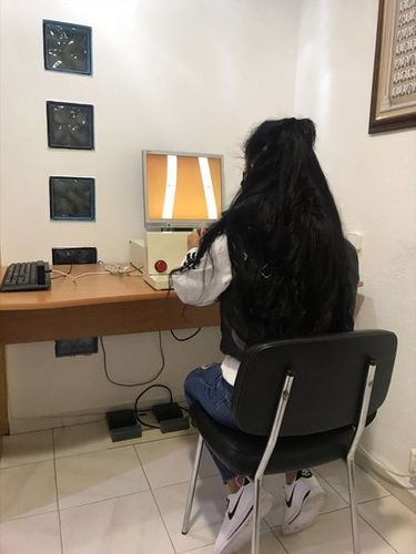 Una mujer se sienta en una silla frente a una computadora