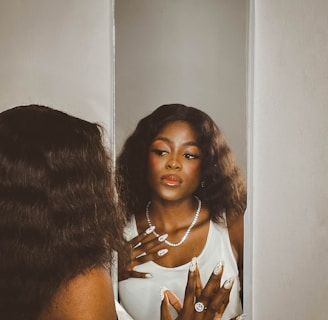 Frau steht vor einem Spiegel