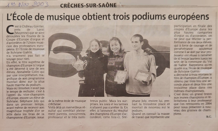 Trois personnes souriantes, avec des trophées. Titre du journal : Une école de musique décroche trois podiums européens.