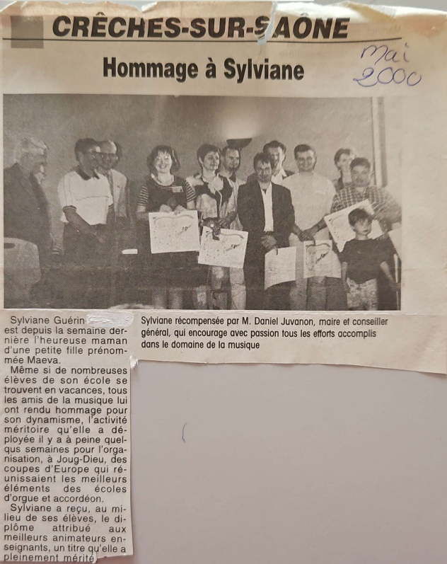 Article de journal concernant Sylviane, avec une photo de groupe présentant des cadeaux.