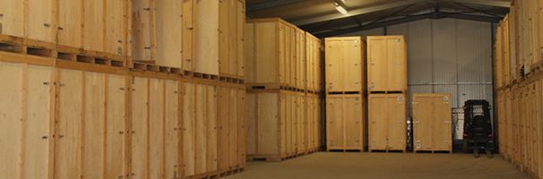 Intérieur d'un entrepôt, avec des rangées d'unités de stockage en bois le long des murs.