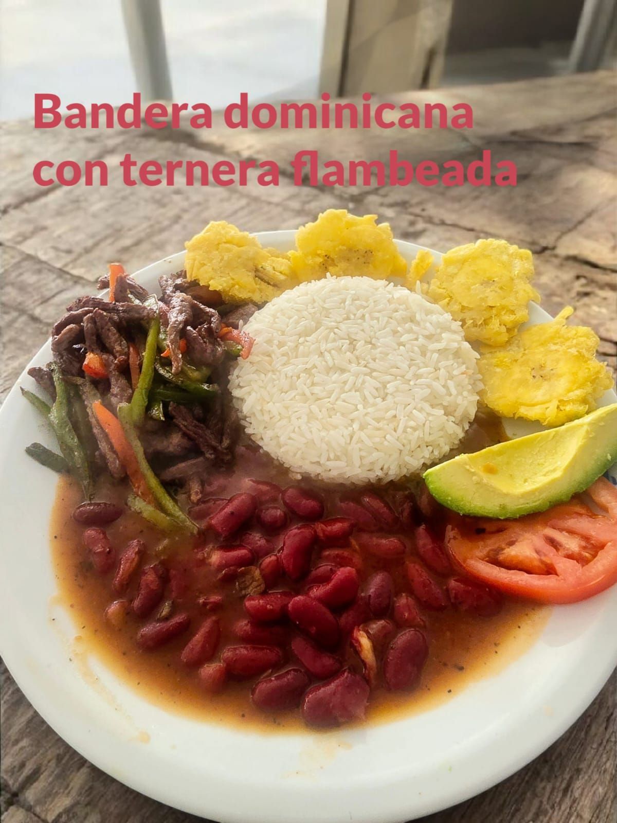 Plato de la bandera dominicana: arroz, frijoles, carne, plátanos, aguacate y tomate en un plato.