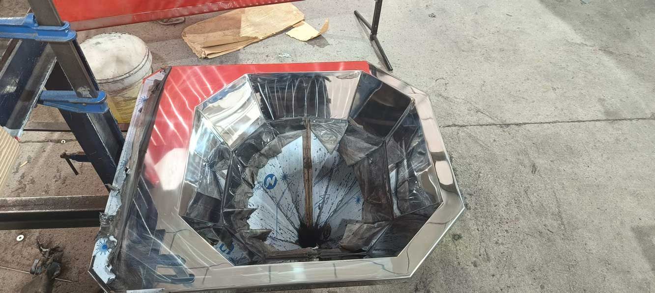 Una estructura metálica octogonal con material reflectante en su interior.