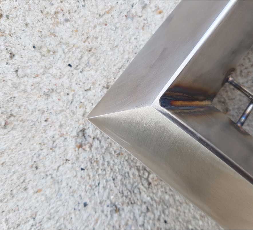 Un artículo de acero inoxidable está sobre una superficie blanca.