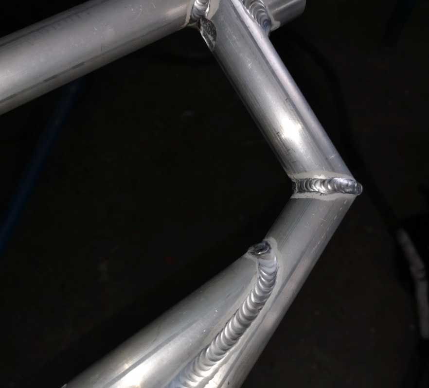 Un primer plano de un cuadro de bicicleta con un fondo negro.