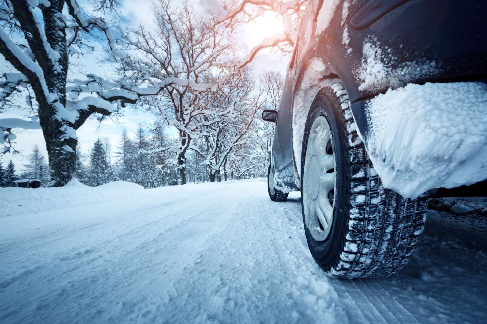 Auto ajaa lumisella tiellä