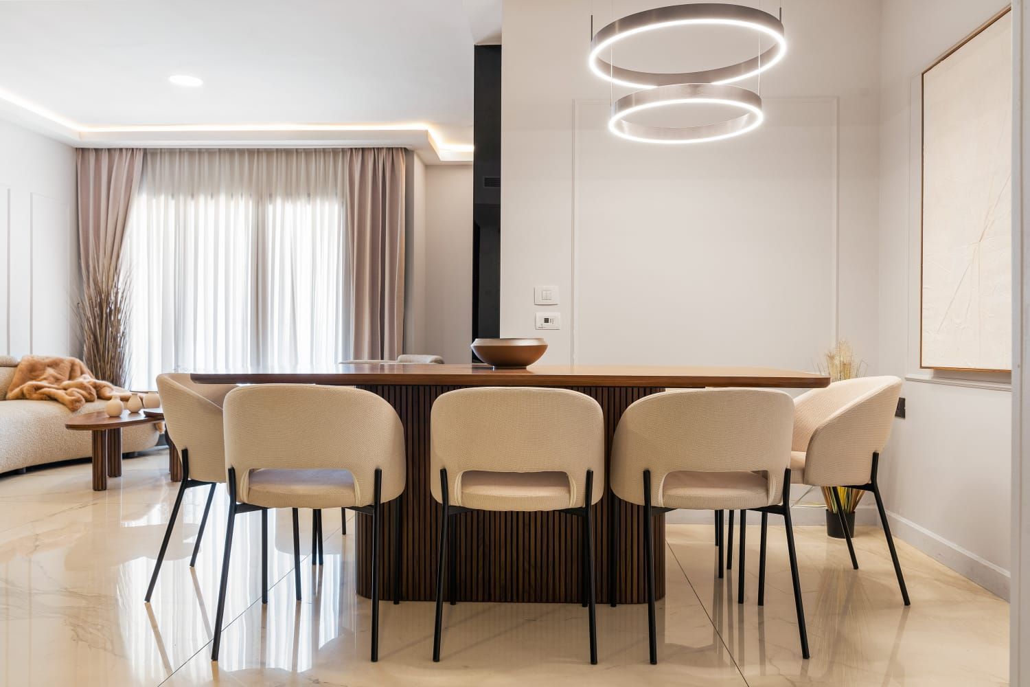 A dining room with a table and chairs in a living room.